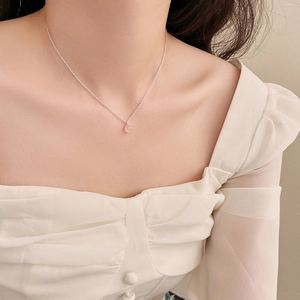 Vue détaillée d'un pendentif en cristal rose facetté sur une fine chaîne argentée