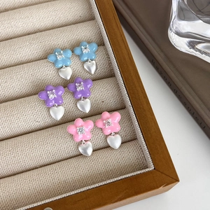 Trois paires de boucles d'oreilles fleurs et cœurs en bleu, violet et rose mat argent