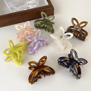 Detailed overhead view of multiple hollow butterfly hair claws in various spring colors