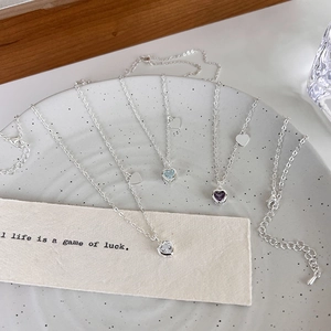 Dettaglio di collane cuore in argento con pendenti in zirconia chiara, blu e viola