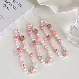 Detail of pink strawberry beaded phone lanyards with hearts, bows and pearls