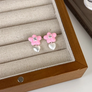 Vue détaillée de boucles d'oreilles fleur rose avec zircon et pendentifs cœur argent