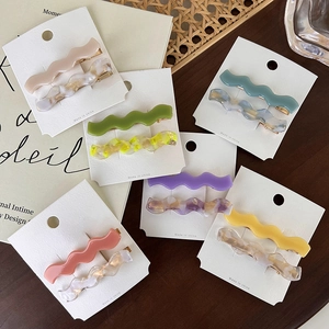 Detail view of acetate wave hairpins set with marble textures and solid colors