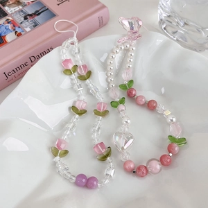 Vue détaillée de deux dragonnes de téléphone avec perles de tulipe rose et nœuds sur l'assiette
