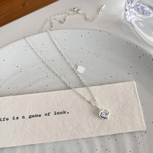 Dettaglio della collana a cuore in argento con zircone su sfondo elegante