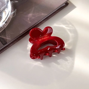 Détail de la pince à cheveux rouge avec texte doré Barrette la France élégant