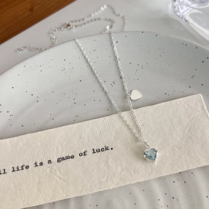 Dettaglio della collana d'argento con cuore in zircone blu e pendente a cuore