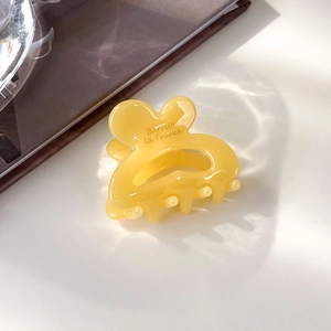 Détail de la pince à cheveux en acrylique jaune avec logo Barrette la France gravé