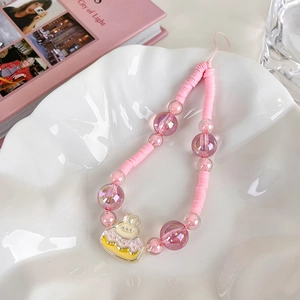 Detail of pink acrylic beads and cute bunny cake pendant on a mobile phone strap