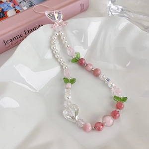 Détail d'une chaîne de téléphone perlée avec tulipes roses et pendentif cœur