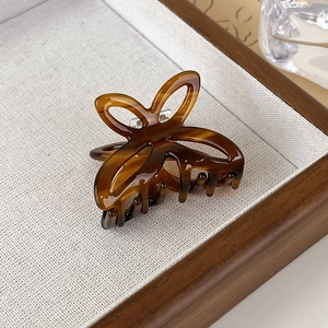 Detailed view of small tortoise shell butterfly hair claw clip with glossy acetate finish