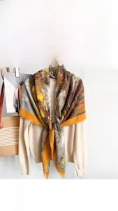 Detail of paisley print cotton linen square scarf draped over a wooden clothes hanger