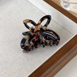 Macro shot of tortoiseshell acetate butterfly hair claw clip with vintage amber patterns