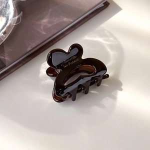Détail d'une pince à cheveux en acétate marron foncé avec logo doré Barrette La France