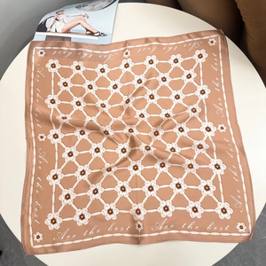 Detail of blue floral silk scarf featuring elegant white patterns and soft camel tones