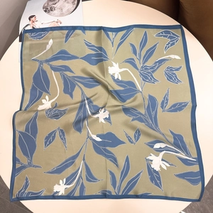 Detailed view of 100% mulberry silk scarf with blue floral print and smooth texture