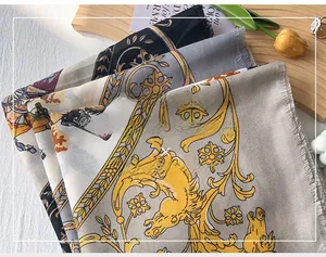 Close-up of luxury silk scarf featuring golden horse motifs and baroque floral patterns