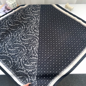 Macro detail of navy paisley and white polka dot silk scarf with contrast stitching