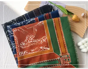 Close-up of folded mercerized wool scarves with chain patterns and fringe details