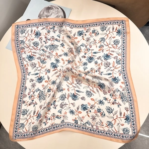 Blue floral 100% mulberry silk scarf draped on table with elegant vintage flower patterns