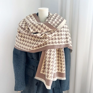 Classic houndstooth jacquard scarf with fringe details on a grey winter wool coat