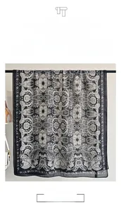 Detail view of the lightweight grey paisley pattern scarf with classic fringe edges