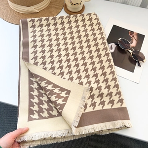 Detail of classic houndstooth scarf with fine tassel edges and thick winter texture