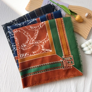 Elegant square scarf with rope pattern and tassels displayed in a cozy lifestyle setting