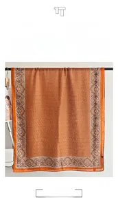 Macro detail of orange cotton linen scarf showing ethnic paisley print and boho textures