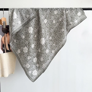 Macro detail of camellia pattern scarf with elegant grey plaid weave and fine texture