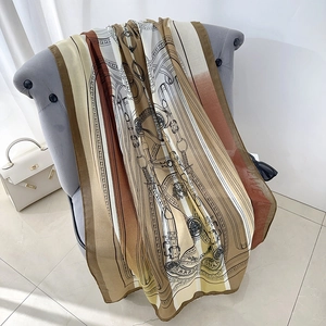 Classic patterned silk scarf with horse motifs draped on a chair for elegant styling