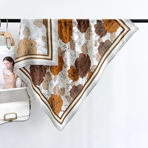 Détail d'un foulard en soie à imprimé roses vintage et bordures rayées sur cintre noir