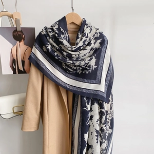 Floral cotton linen scarf in navy and beige draped over a wool coat for autumn