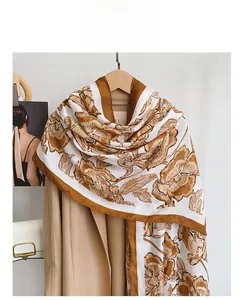 Detailed texture of cotton linen floral scarf styled on a beige wool coat