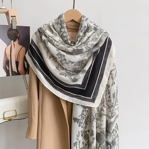 Detail of French vintage floral pattern scarf draped over a classic camel wool coat