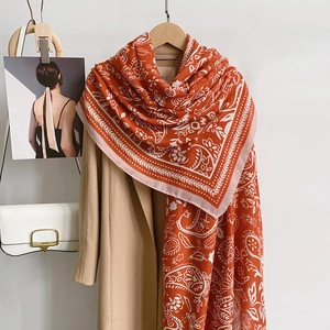 Chal étnico naranja con estampado paisley tacto cachemira y abrigo color beige
