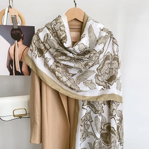 Detail of floral printed cotton linen scarf with elegant green patterns on white fabric