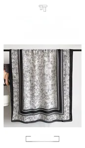 Detail of white cotton linen scarf featuring black bamboo ink patterns and draped texture