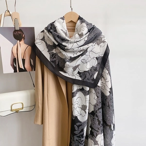 Close-up of lightweight cotton linen scarf with black and white artistic floral patterns