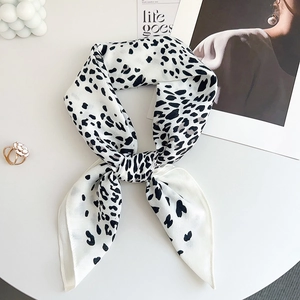 Detailed view of leopard print silk scarf with black spots and chic lifestyle accessories