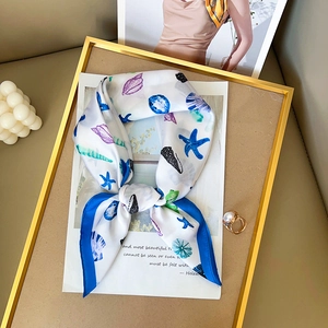 Elegant silk scarf with blue starfish and purple shell prints on a white background