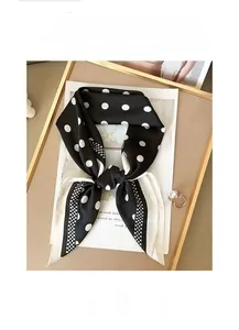 Detail of black and white polka dot silk scarf featuring breathable and soft fabric texture
