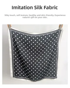Detail view of faux silk polka dot scarf featuring checkered borders and smooth texture