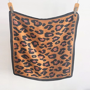 Detail of leopard print cotton linen square scarf with red and black pattern accents