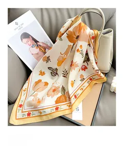 Floral silk scarf with cat prints draped over a leather bag in a cozy home setting