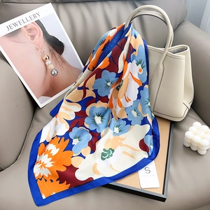 Détail d'un foulard en soie élégant à imprimé floral drapé sur un sac fourre-tout