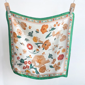Detail of floral silk scarf with green stripes and orange flowers on white background