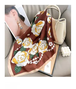 Détail du foulard en soie à imprimé floral drapé sur un sac à main élégant