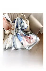 Detail of elegant floral silk satin scarf elegantly draped with fashion accessories