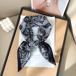 Elegant black and white paisley silk scarf in a stylish scene with pearls and rings